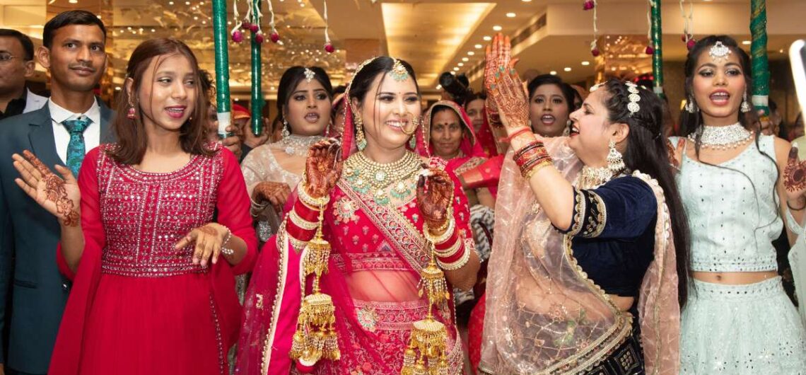 Indian wedding sangeet ceremony with bride and foreign guests dancing in colorful traditional outfits